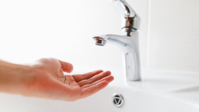 hand under faucet without water