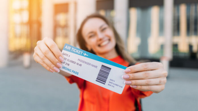 Caucasian girl joyful holding an air ticket for the plane and travel in her hands
